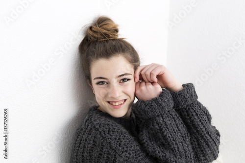 Young woman smelling on a white background.