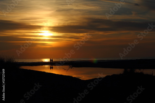 Lovers walking on the beach at sunset