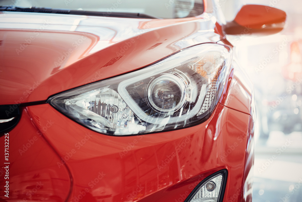 Headlights and hood of sport red car.