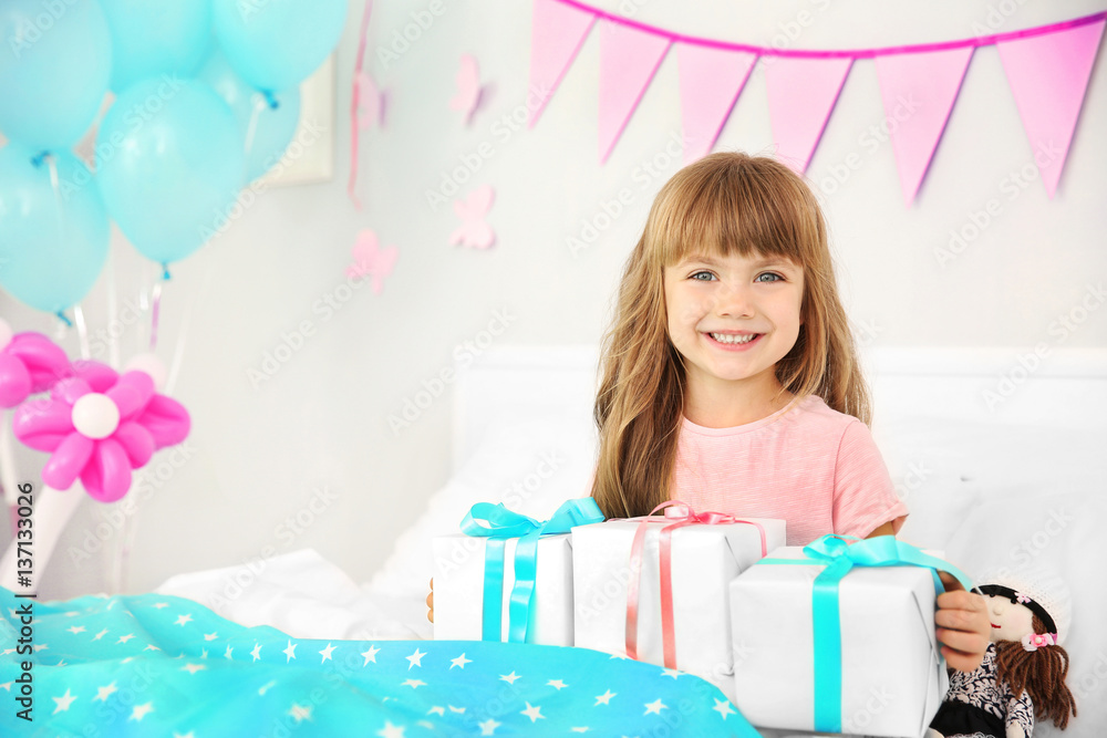 Cute birthday girl sitting on bed with giftboxes Cute birthday girl sitting on bed with giftboxes