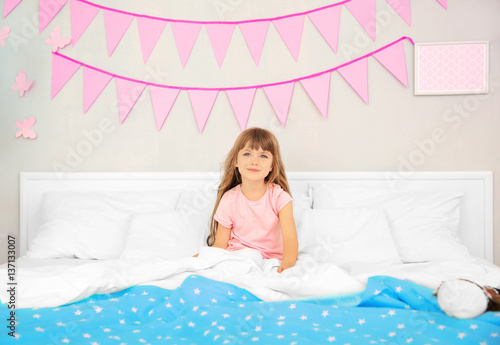 Cute birthday girl in bed a...