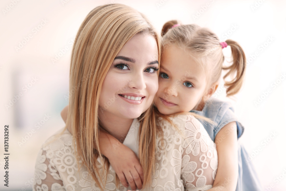 Beautiful young woman and her daughter at home. Mother's day concept Beautiful young woman and her daughter at home. Mother's day concept