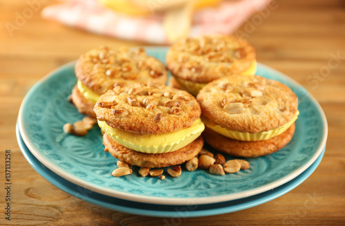 Plate with delicious lemon ice cream cookie sandwiches on wooden table