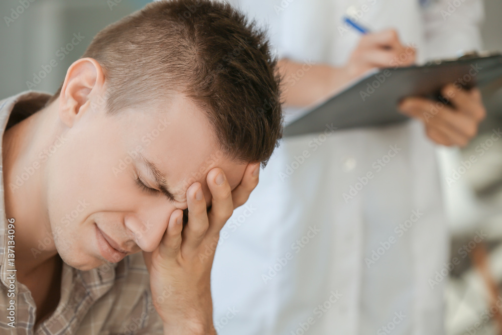 Young depressed man at doctor's office, closeup Young depressed man at doctor's office, closeup