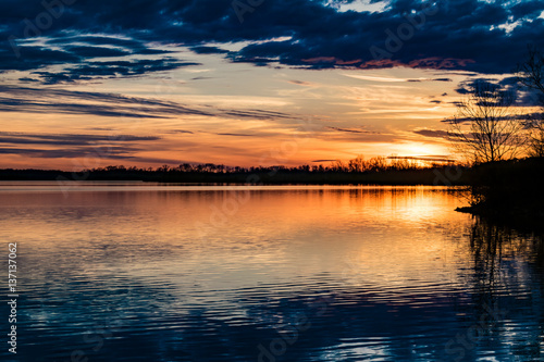 Colorful orange sunset reflected off the lake © Lenny Buzz