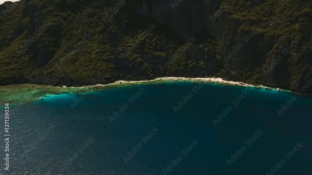 Tropical lagoon with turquoise water and white sand. Blue Lagoon with tourists and motor boats. Beautiful beach. Tropical bay in El Nido. Aerial view: bay and the tropical island. Aerial video Tropical lagoon with turquoise water and white sand. Blue Lagoon with tourists and motor boats. Beautiful beach. Tropical bay in El Nido. Aerial view: bay and the tropical island. Aerial video