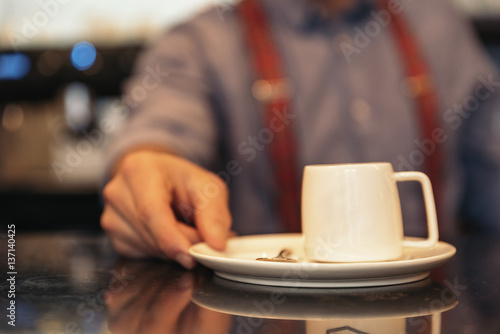 Waiter holding a tray with coffees.