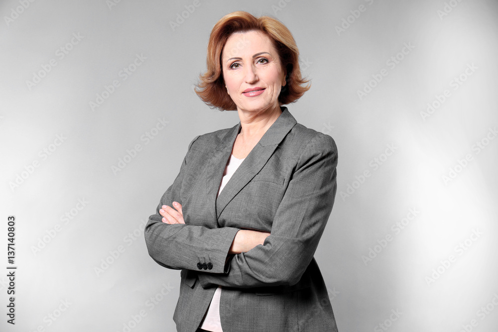 Portrait of gorgeous senior woman with crossed hands on colour background Portrait of gorgeous senior woman with crossed hands on colour background