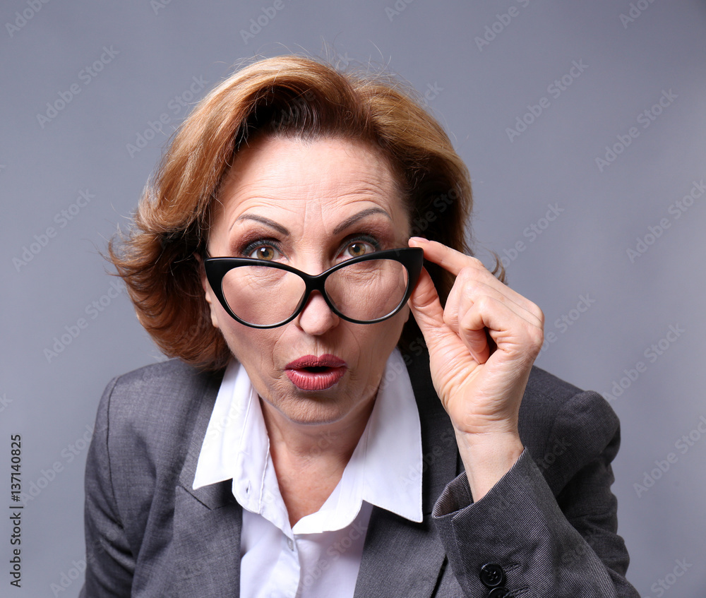 Portrait of gorgeous senior woman with eyeglasses on colour background, closeup Portrait of gorgeous senior woman with eyeglasses on colour background, closeup