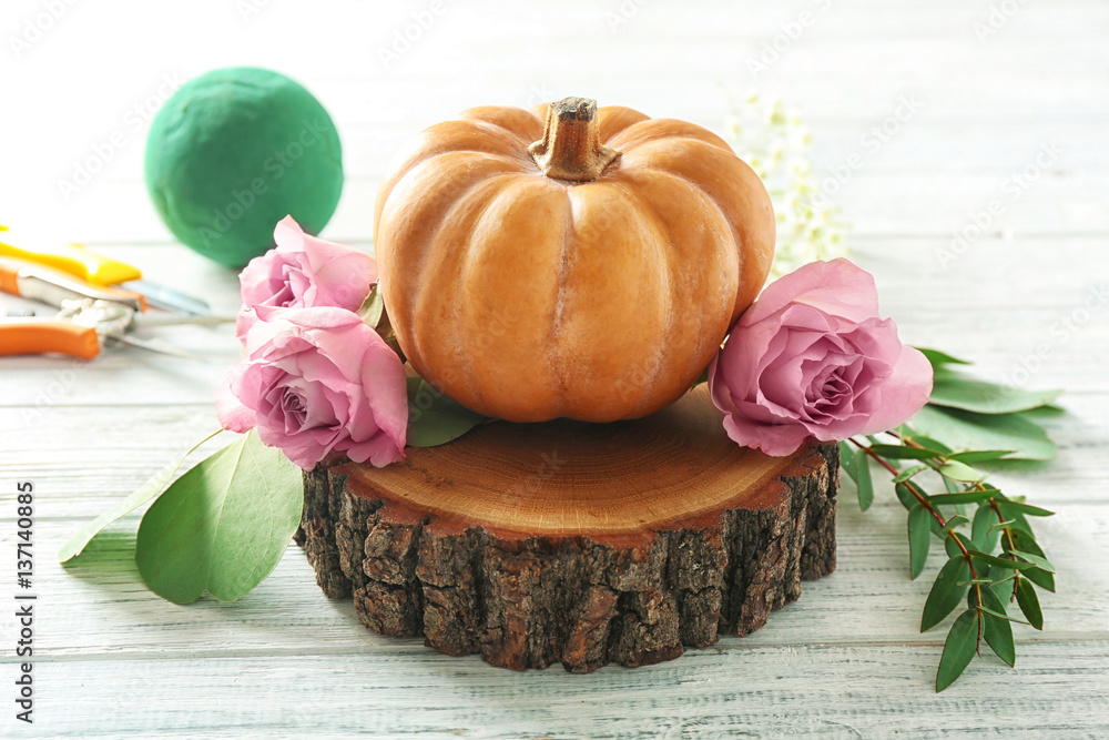 Pumpkin and fresh flowers on white wooden table Pumpkin and fresh flowers on white wooden table