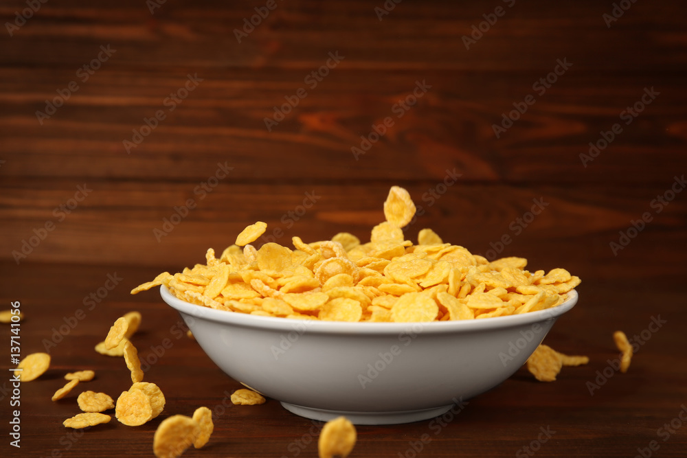 Bowl with corn flakes on wooden background Bowl with corn flakes on wooden background