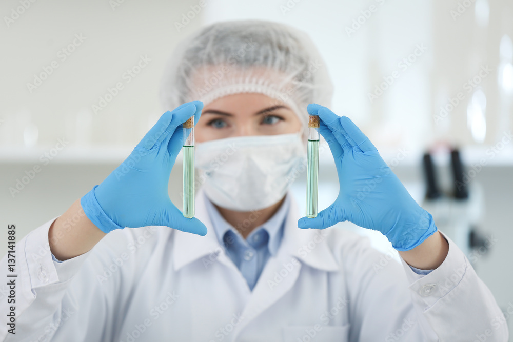Scientist holding test tubes with samples in laboratory Scientist holding test tubes with samples in laboratory