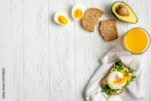 sandwich with poached eggs on wooden background top view mockup
