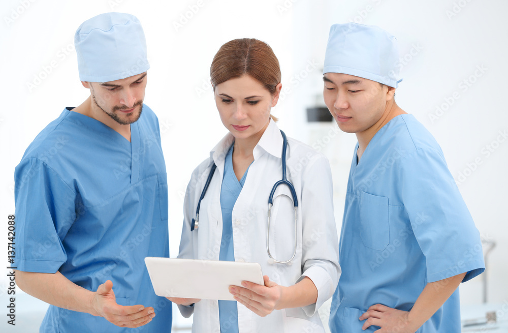 Young doctors with tablet computer in modern clinic Young doctors with tablet computer in modern clinic