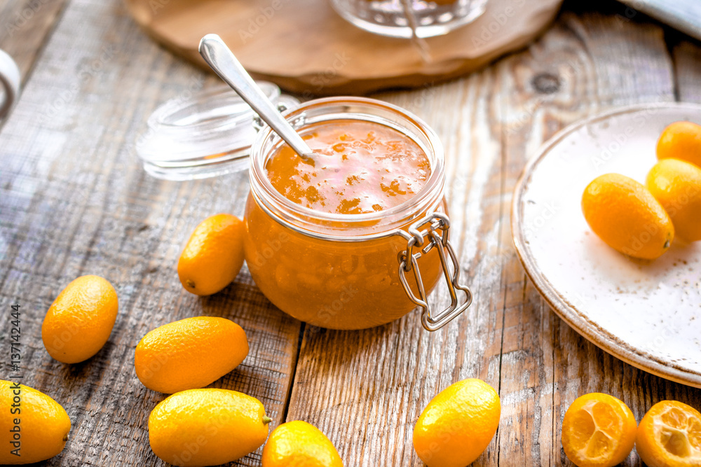 kumquat on plate and jam in jar at wooden table kumquat on plate and jam in jar at wooden table