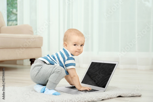 Cute baby boy with laptop o...