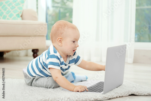 Cute baby boy with laptop o...