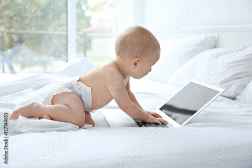 Cute baby boy with laptop o...
