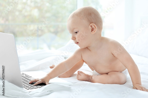Cute baby boy with laptop o...