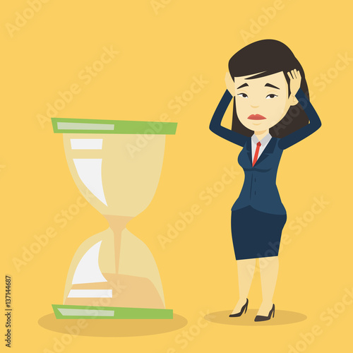 Desperate business woman looking at hourglass. photo