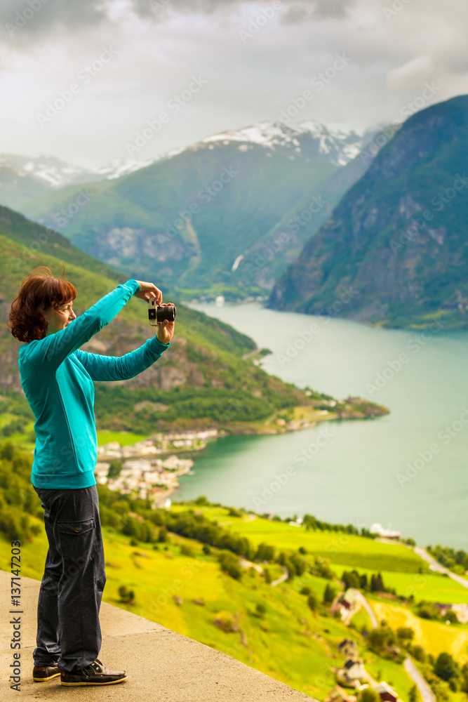 Female tourist taking photo at norwegian fjord