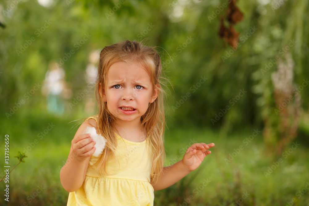 Cute little girl eating candy floss. A walk in the summer park. Summer vacation. Outdoor Activities. Cute little girl eating candy floss. A walk in the summer park. Summer vacation. Outdoor Activities.