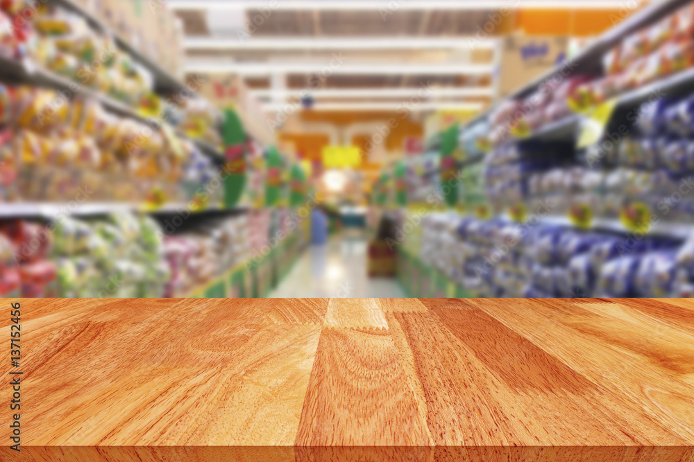 Wood table top with blurred supermarket store  background 