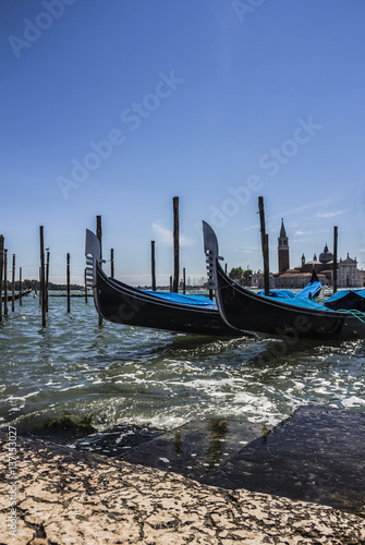 Gondolas and San Giorgio maggiore, view from San Marco square, in Venice, Italy © yos_moes