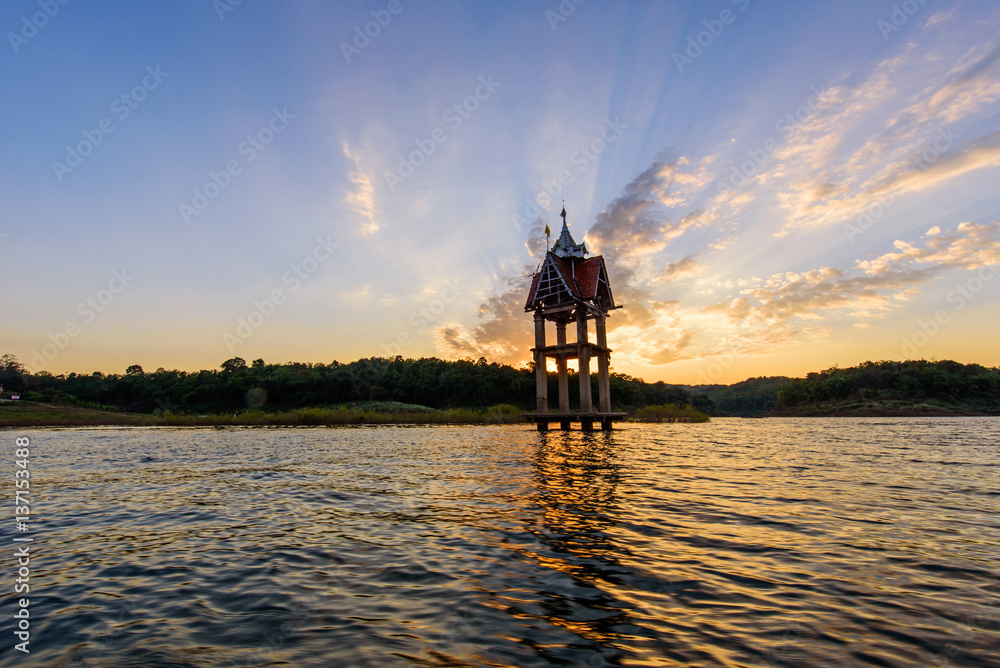 Fototapeta premium carcass of old temple at the lake in sunset time