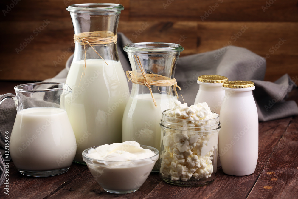 milk products - tasty healthy dairy products on a table on: sour cream in a white bowl, cottage cheese bowl, cream in a a bank and milk jar, glass bottle and in a glass milk products - tasty healthy dairy products on a table on: sour cream in a white bowl, cottage cheese bowl, cream in a a bank and milk jar, glass bottle and in a glass