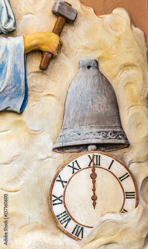 hand holding hammer on clock and bell