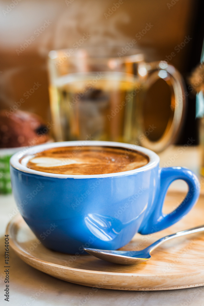 Close up coffee cup with steam on table in cafe. Close up coffee cup with steam on table in cafe.