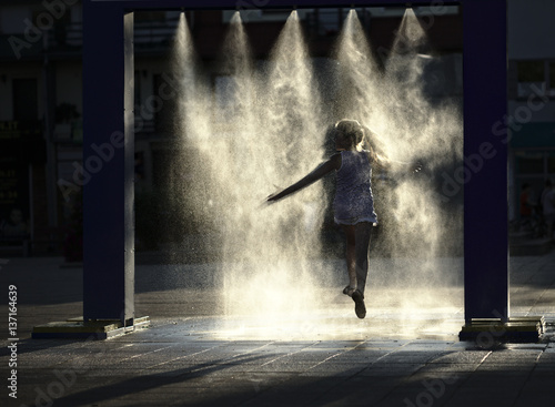 Girl is enjoying spray with cold water