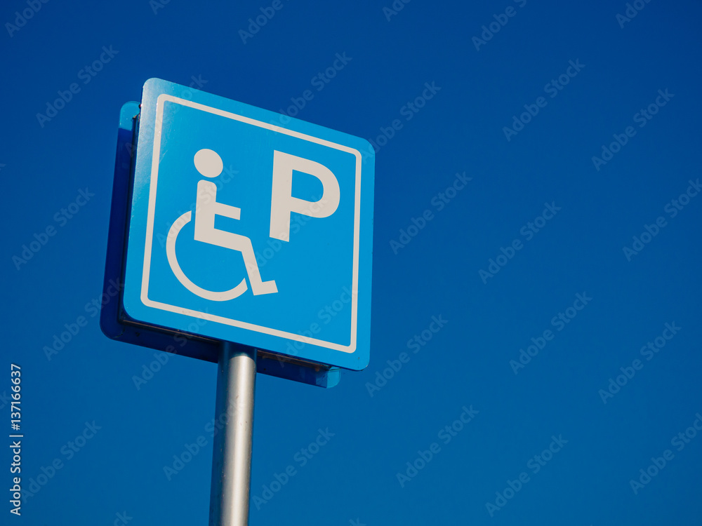 Disabled parking space and wheelchair way sign and symbols on a pole warning motorists Disabled parking space and wheelchair way sign and symbols on a pole warning motorists