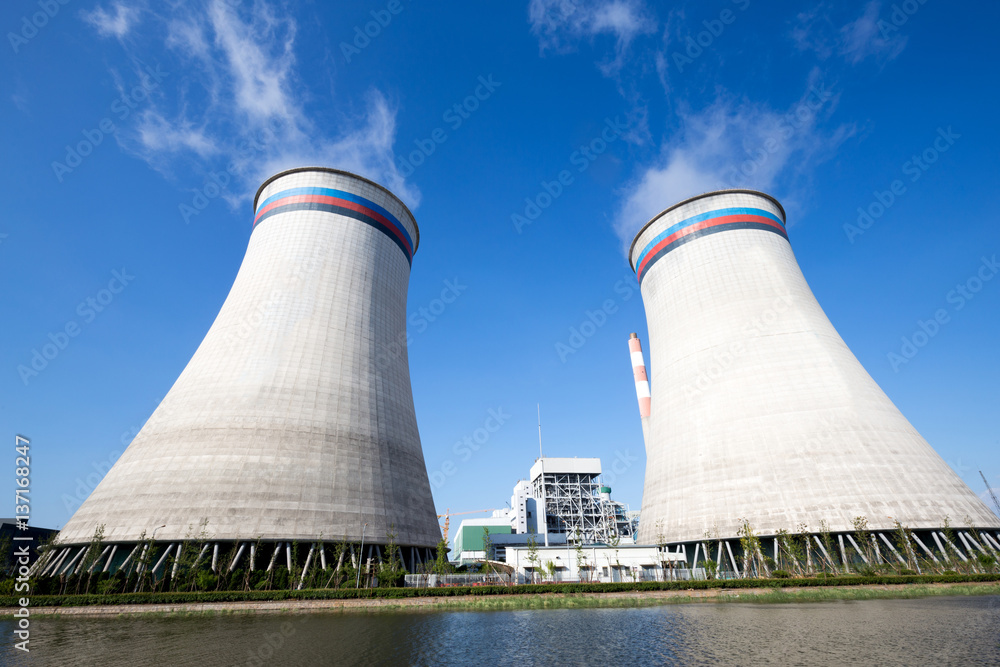 modern power plant near river in blue sky