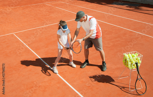 Tennis coach with talented young girl © Microgen