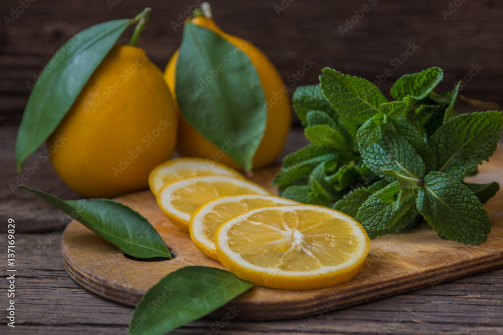 Fresh mint and lemon slices on wooden board Fresh mint and lemon slices on wooden board