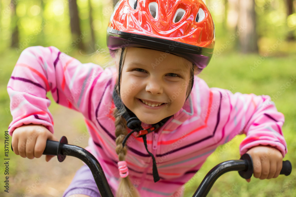 Little girl riding a bicycle in the woods Little girl riding a bicycle in the woods