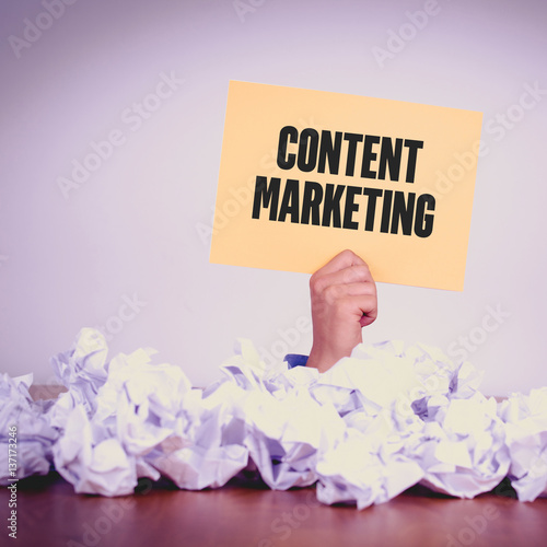 HAND HOLDING YELLOW PAPER WITH CONTENT MARKETINGCONCEPT photo