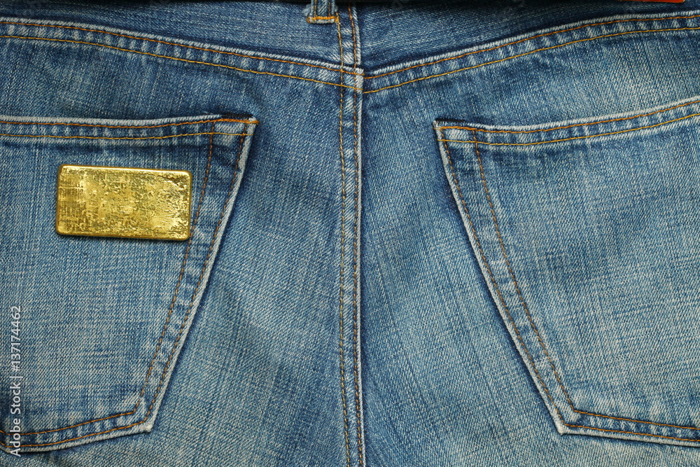 The gold bar put in the jean pocket background represent gold and business finance concept related idea. The gold bar put in the jean pocket background represent gold and business finance concept related idea.