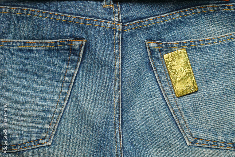 The gold bar put in the jean pocket background represent gold and business finance concept related idea. The gold bar put in the jean pocket background represent gold and business finance concept related idea.