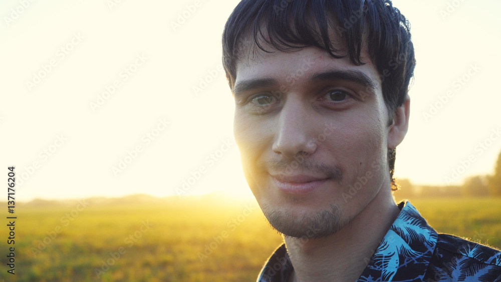 Portrait of smiles man looking at the sun during beautiful sunset with lense flare effects. Portrait of smiles man looking at the sun during beautiful sunset with lense flare effects.