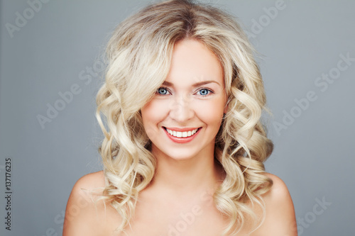 Young Blonde Woman with Curly Hair Smiling. Happy Fashion Model Closeup