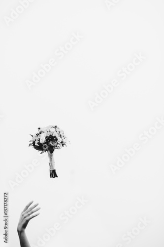 hand and bride's bouquet in the air