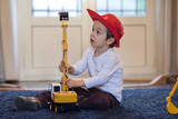 Child, playing at home with plastic excavator
