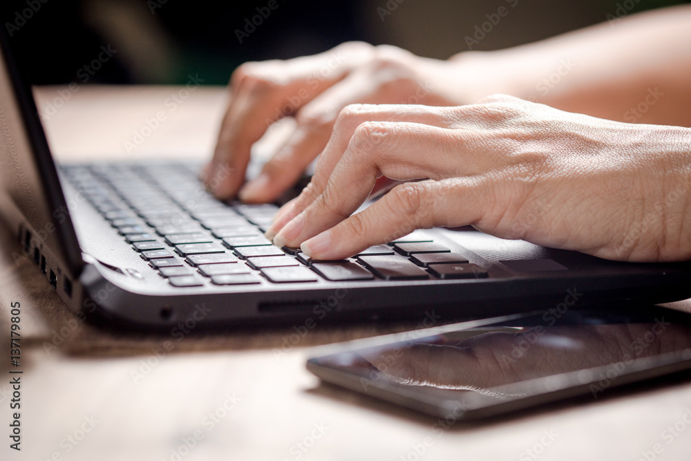 Closeup of business woman hand typing on laptop keyboard, lighting effect Closeup of business woman hand typing on laptop keyboard, lighting effect