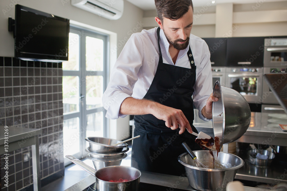Chef pouring chocolate in bowl. Chef pouring chocolate in bowl.