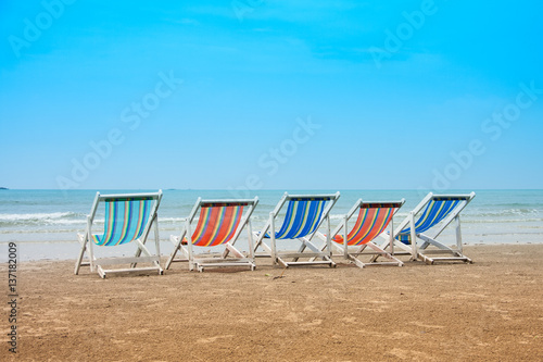 Fototapeta Naklejka Na Ścianę i Meble -  Group of empty deck chairs on sea beach. Vacation with friends concept
