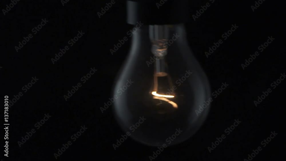 Light bulb swinging and flickering. Slow motion. Stock Video Adobe Stock