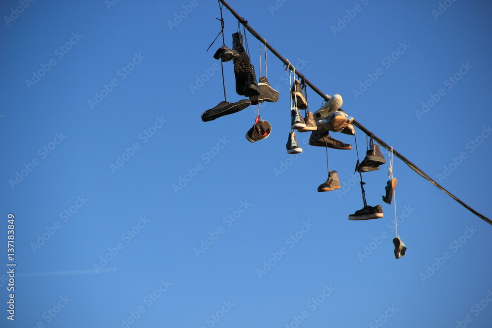 Shoes hanging on a rope against the blue sky Shoes hanging on a rope against the blue sky